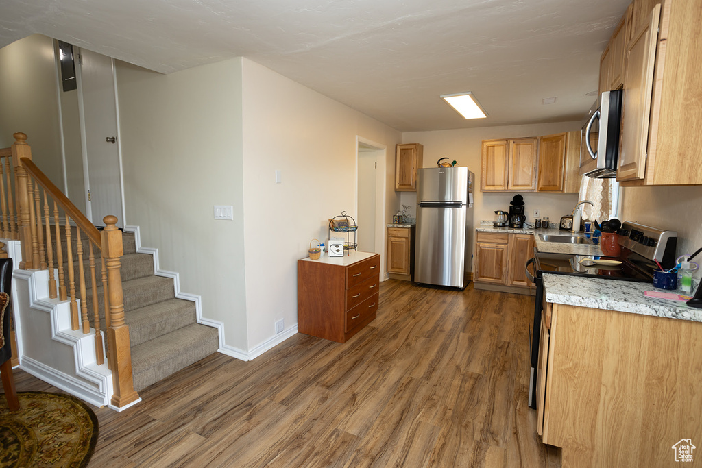 Kitchen featuring dark wood-type flooring and appliances with stainless steel finishes