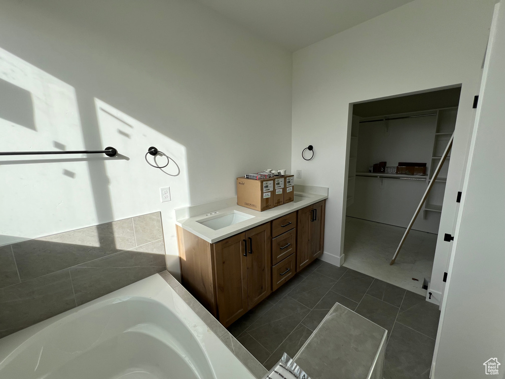 Bathroom with vanity, a tub, and tile patterned floors