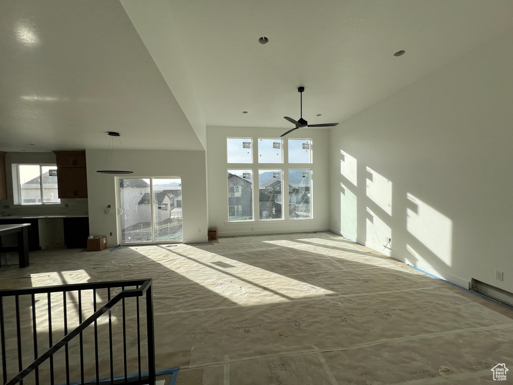 Unfurnished living room featuring ceiling fan