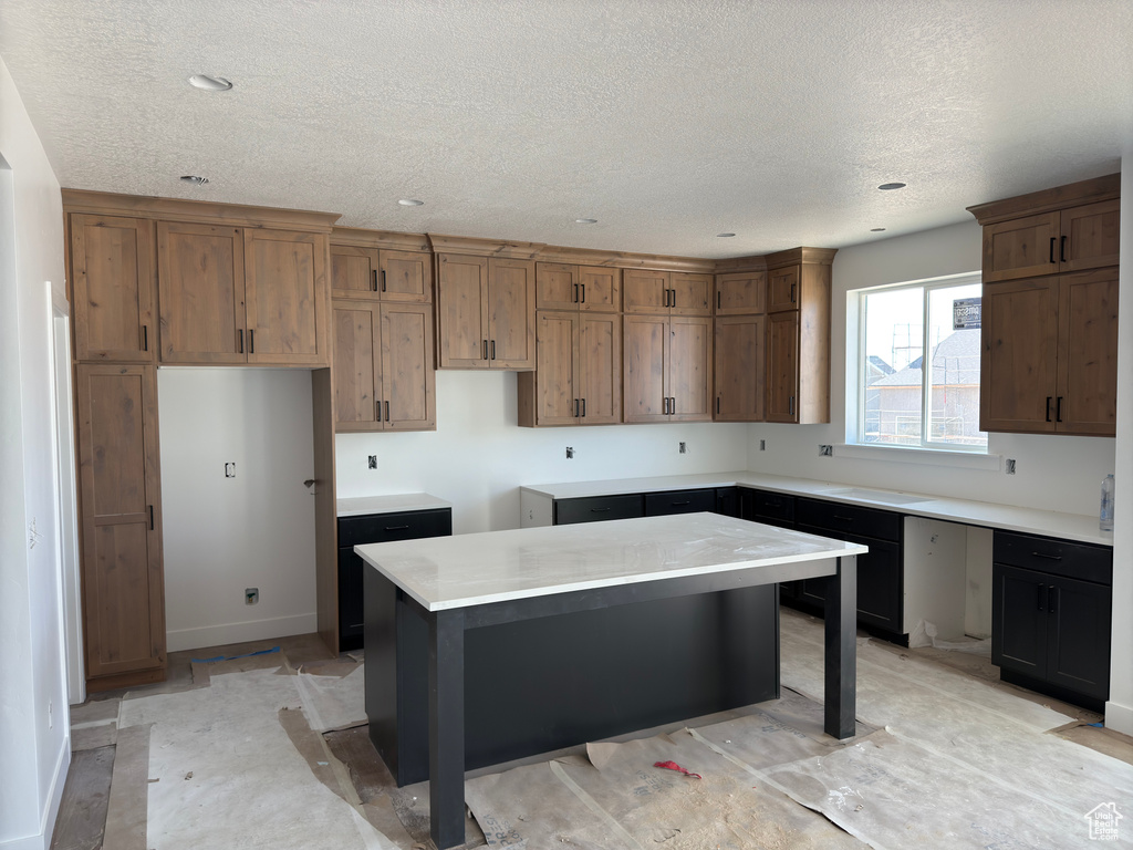 Kitchen featuring a kitchen island, a breakfast bar, and a textured ceiling