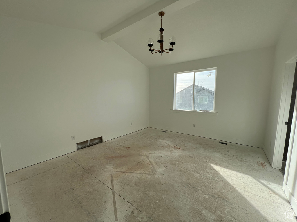 Spare room with a chandelier and vaulted ceiling with beams