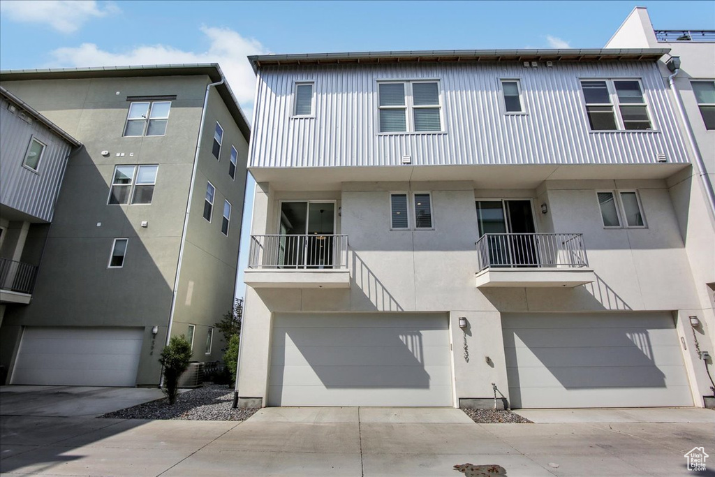 View of property with a balcony and a garage