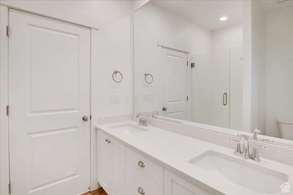 Bathroom with vanity, toilet, and an enclosed shower