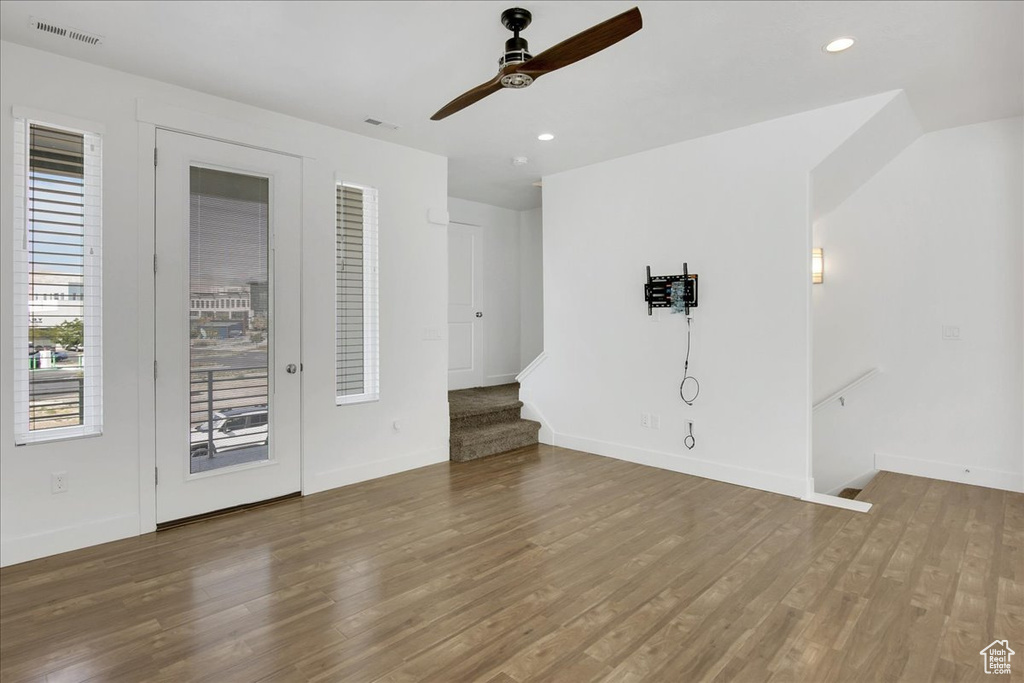 Unfurnished living room featuring hardwood / wood-style floors and ceiling fan