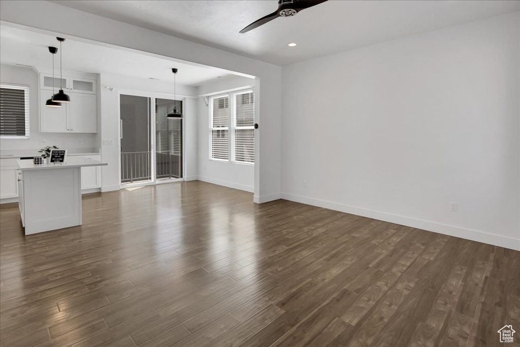 Unfurnished living room with ceiling fan and dark hardwood / wood-style floors