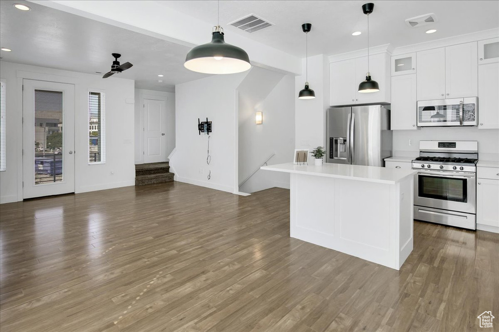 Kitchen featuring a center island, stainless steel appliances, dark hardwood / wood-style floors, ceiling fan, and pendant lighting