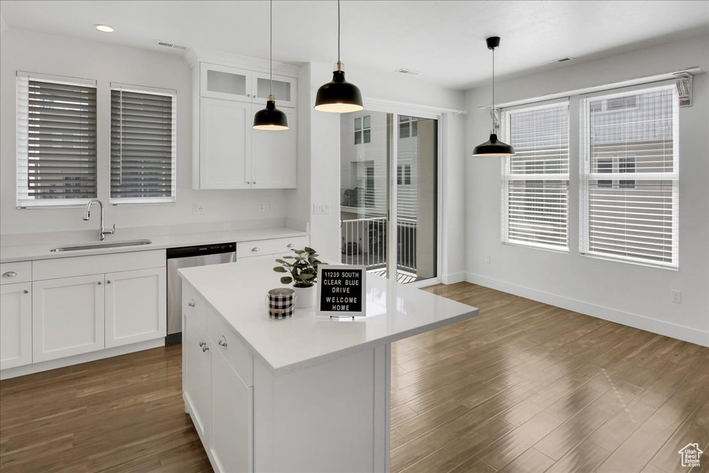 Kitchen featuring white cabinets, hardwood / wood-style floors, a wealth of natural light, and a kitchen island