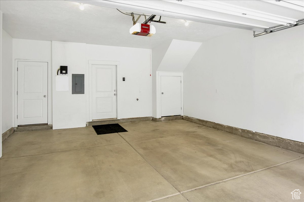 Garage featuring a garage door opener and electric panel