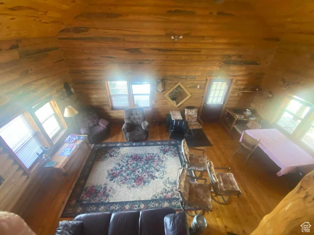 Living room with wooden walls and hardwood / wood-style flooring