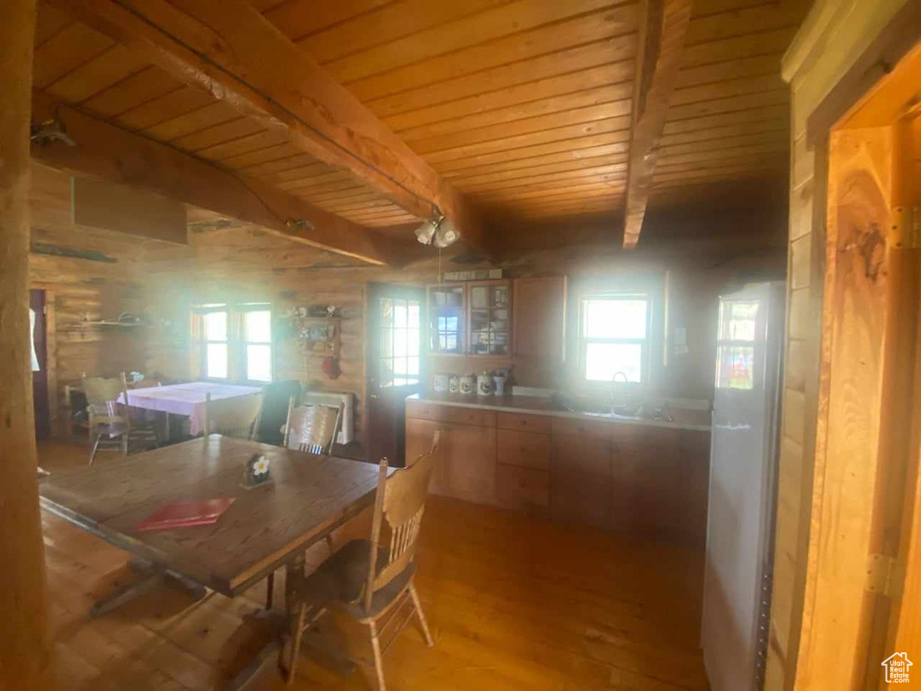 Dining space with a wealth of natural light, wooden ceiling, wood-type flooring, and beam ceiling