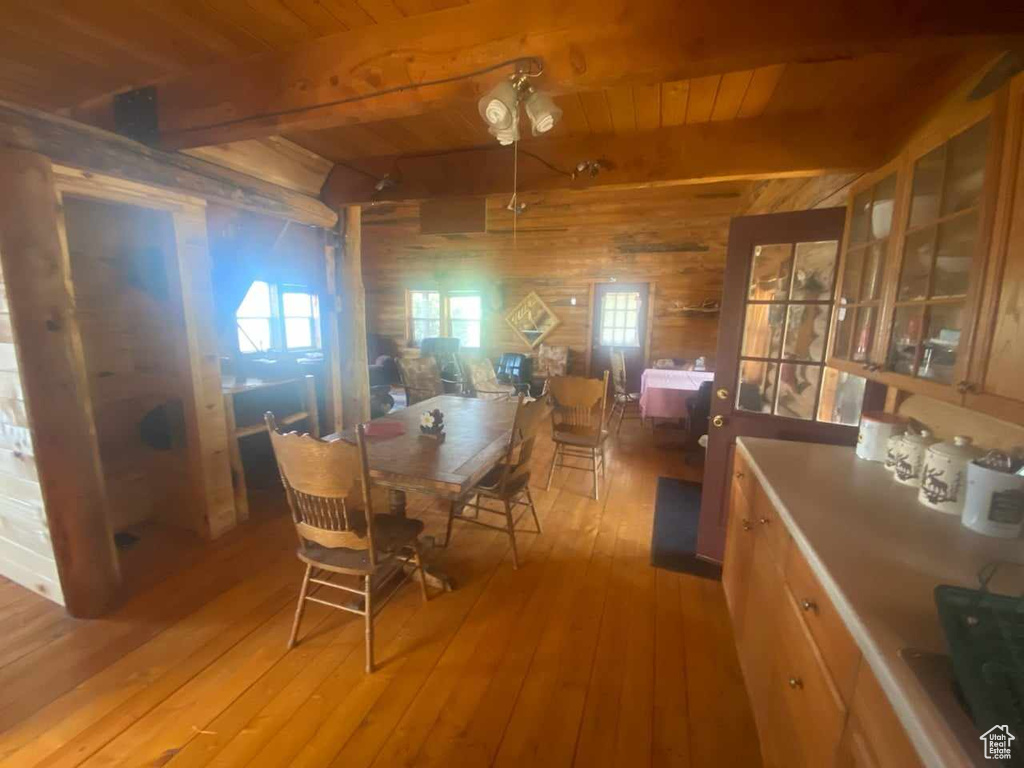 Dining space featuring wood ceiling, light hardwood / wood-style flooring, and beamed ceiling