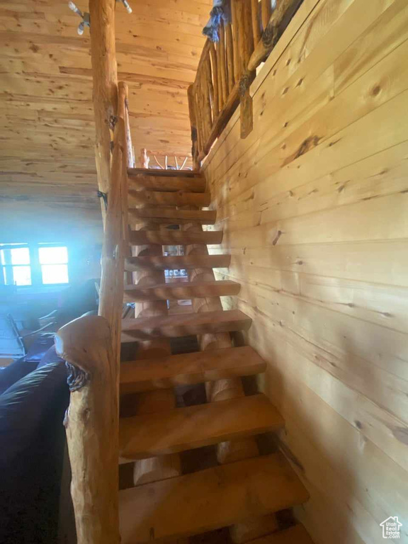 Stairway featuring wooden walls