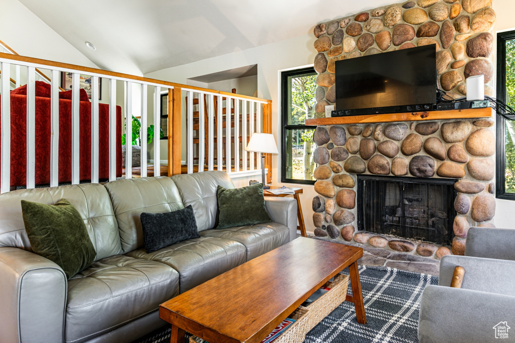 Living room featuring lofted ceiling and a fireplace