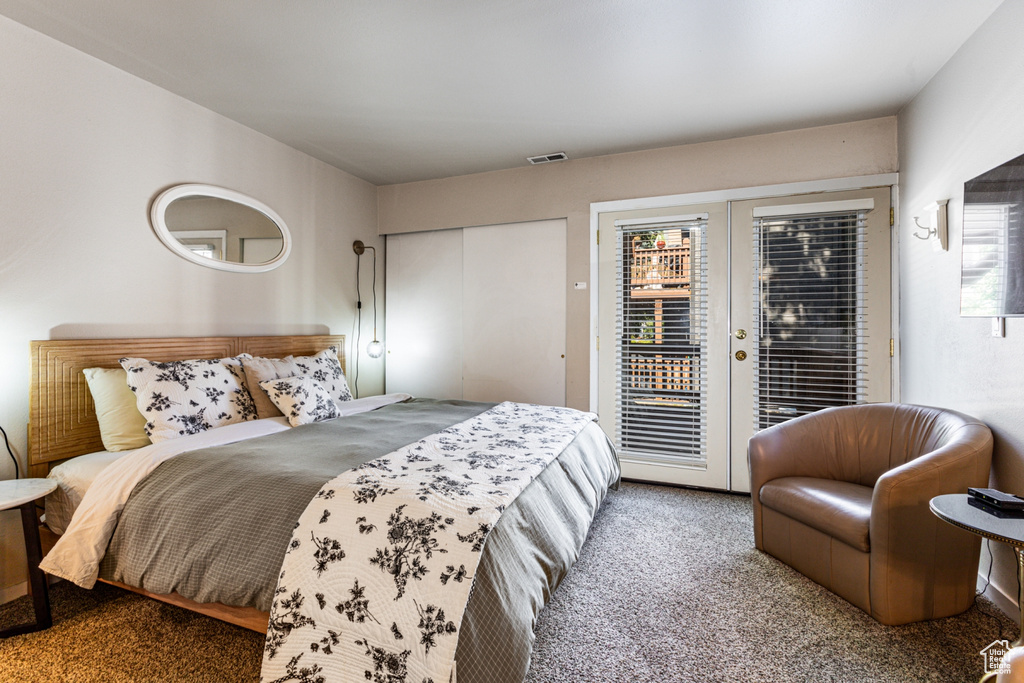 Bedroom with access to exterior, carpet flooring, and multiple windows