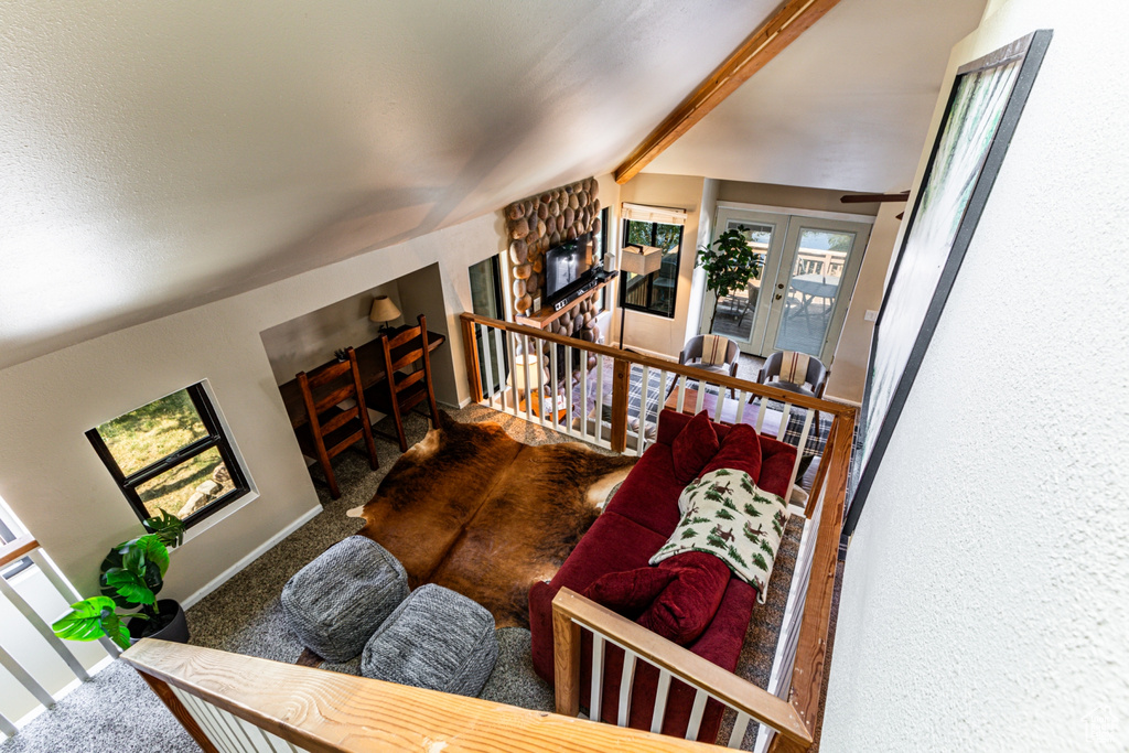 Living room with french doors, carpet flooring, and vaulted ceiling with beams