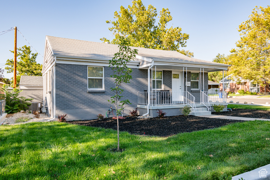 View of front of property featuring covered porch and a front lawn