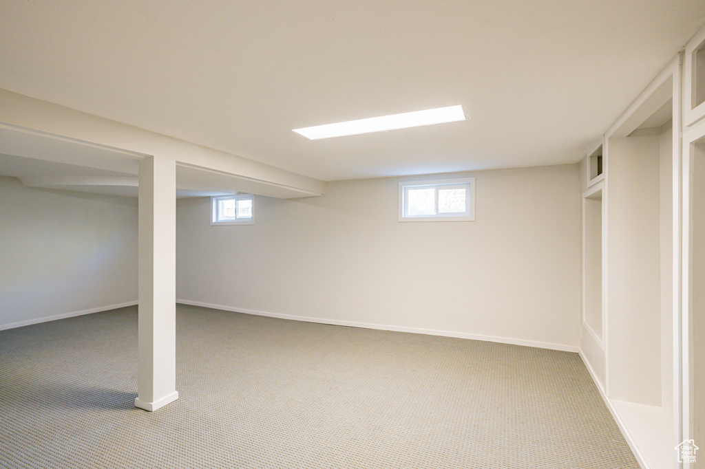 Basement with a wealth of natural light and carpet