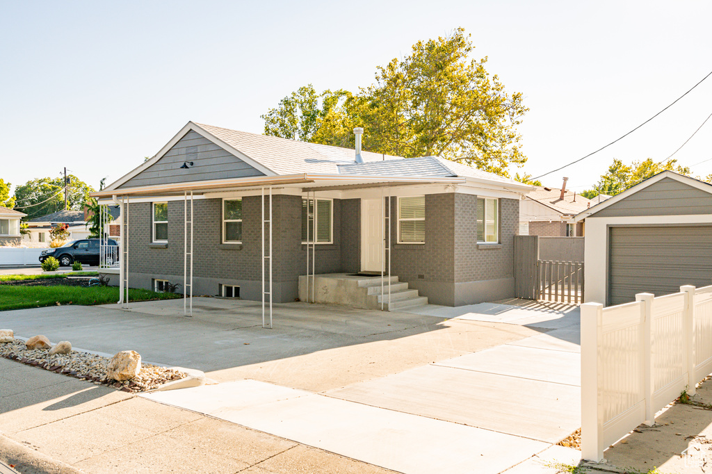 View of front of home featuring a garage and an outbuilding