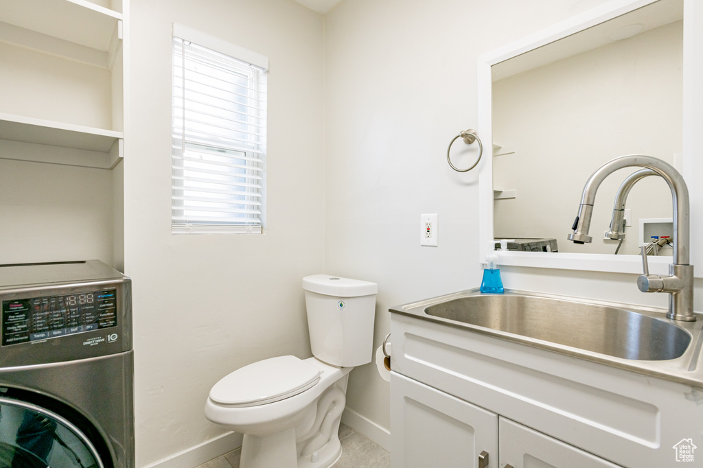 Bathroom with vanity, toilet, tile patterned floors, and washer / clothes dryer