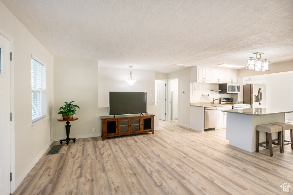 Interior space with light wood-type flooring and a textured ceiling