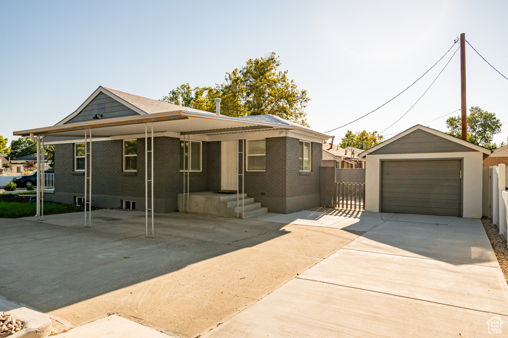 View of front of home featuring a garage and an outbuilding