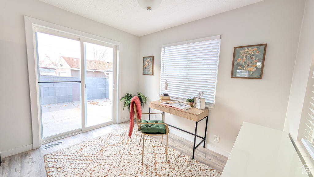 Home office with a textured ceiling and light hardwood / wood-style flooring