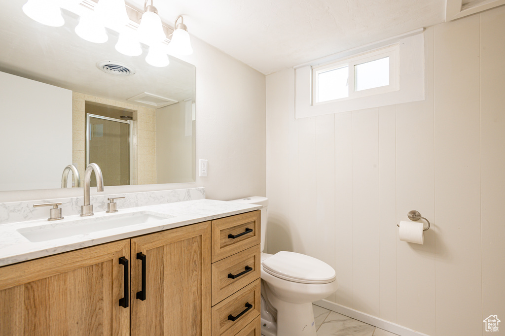 Bathroom featuring vanity, toilet, and walk in shower