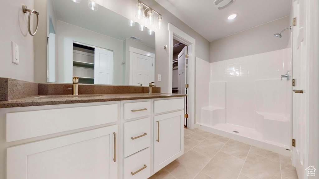 Bathroom with a shower, vanity, and tile patterned floors