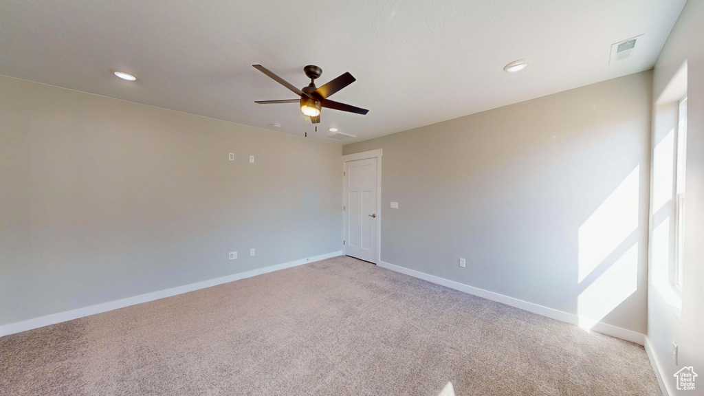 Carpeted empty room with ceiling fan