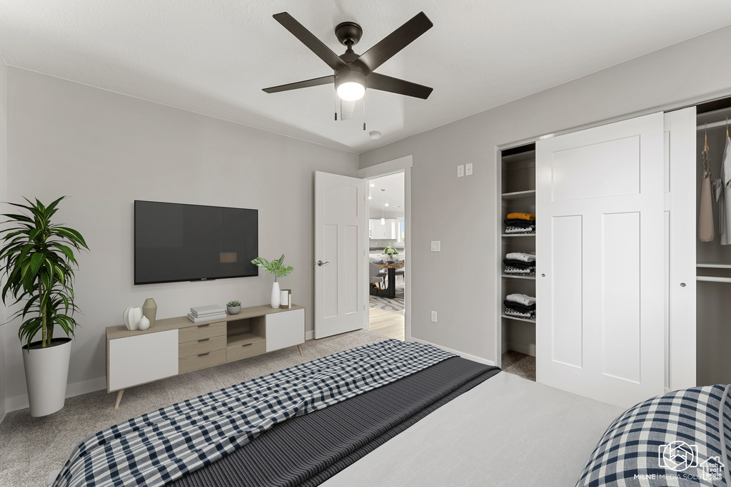 Bedroom with a closet, ceiling fan, and light colored carpet