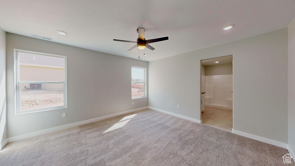 Empty room with ceiling fan and light colored carpet