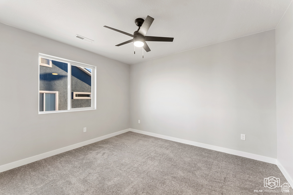 Carpeted empty room featuring ceiling fan