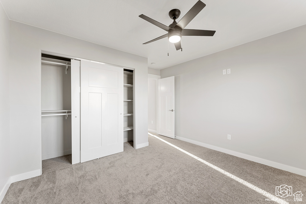 Unfurnished bedroom featuring ceiling fan and light colored carpet