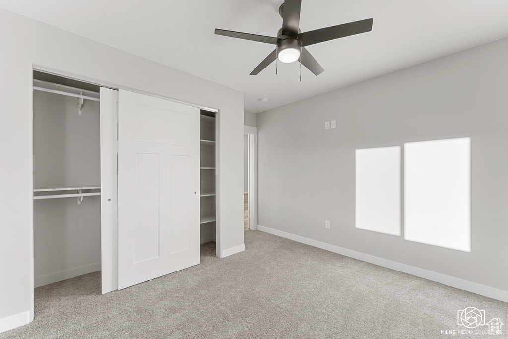 Unfurnished bedroom featuring ceiling fan and light carpet