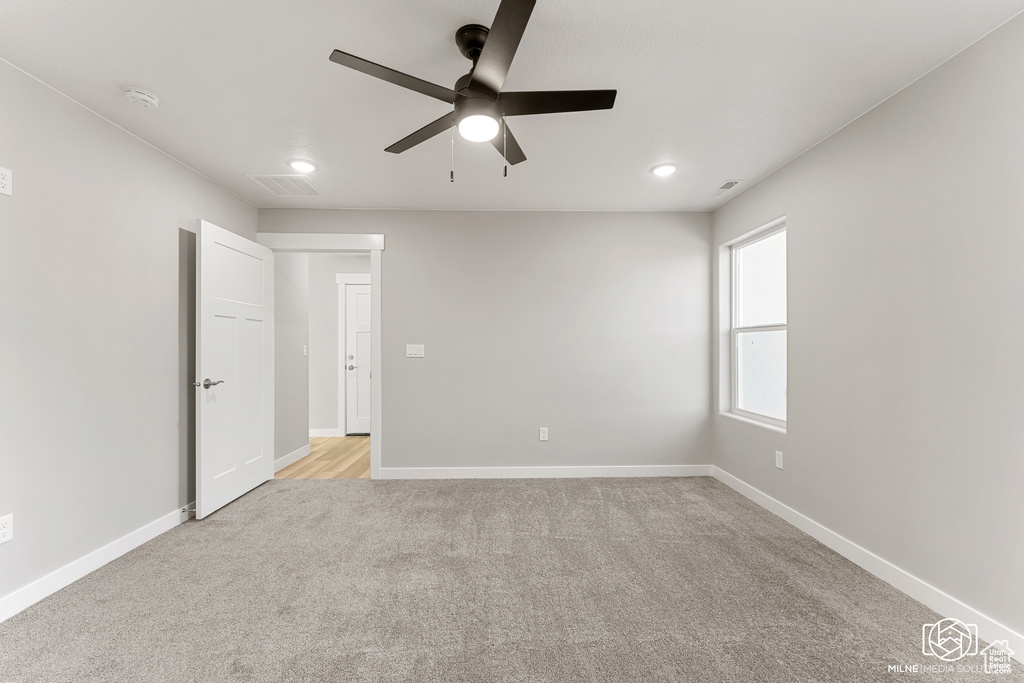 Carpeted spare room with ceiling fan