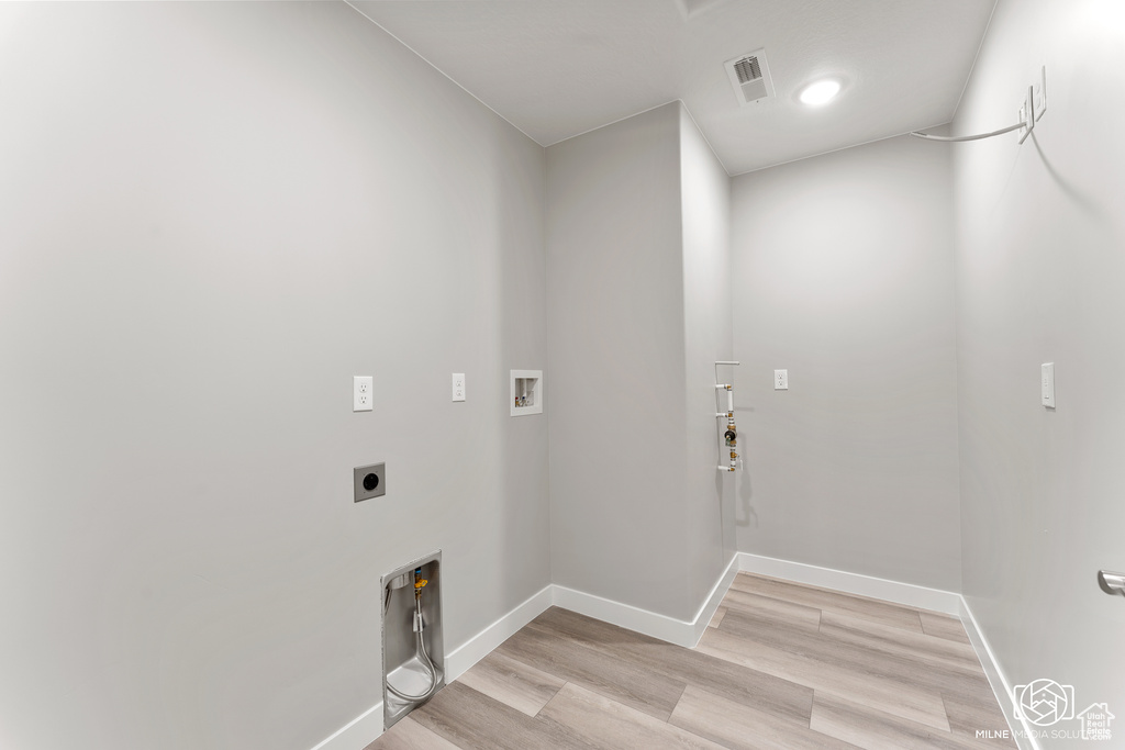 Laundry area with hookup for a washing machine, light wood-type flooring, and electric dryer hookup