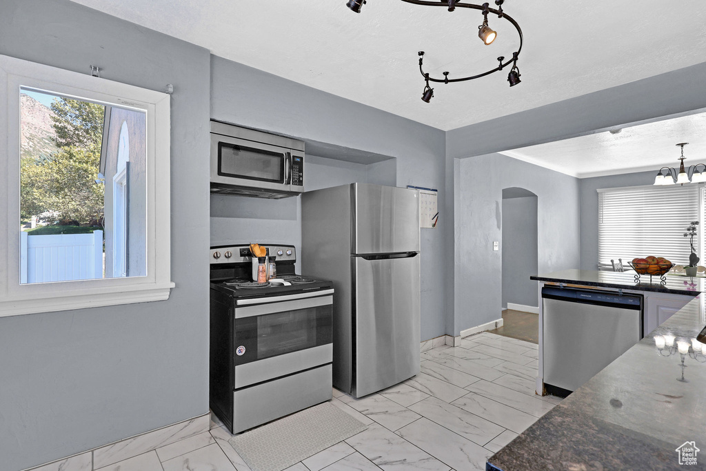 Kitchen featuring stainless steel appliances and dark stone counters