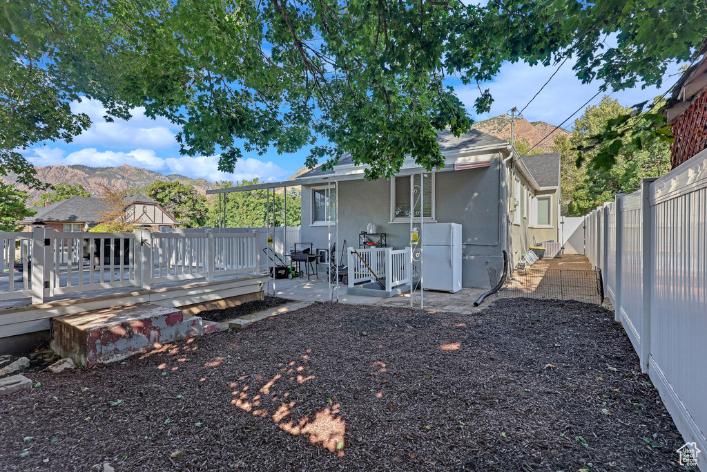 Back of property featuring a deck with mountain view