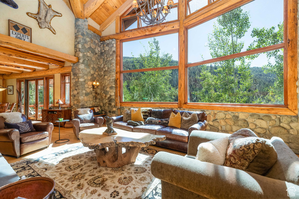 Living room with hardwood / wood-style floors, high vaulted ceiling, a fireplace, and beam ceiling