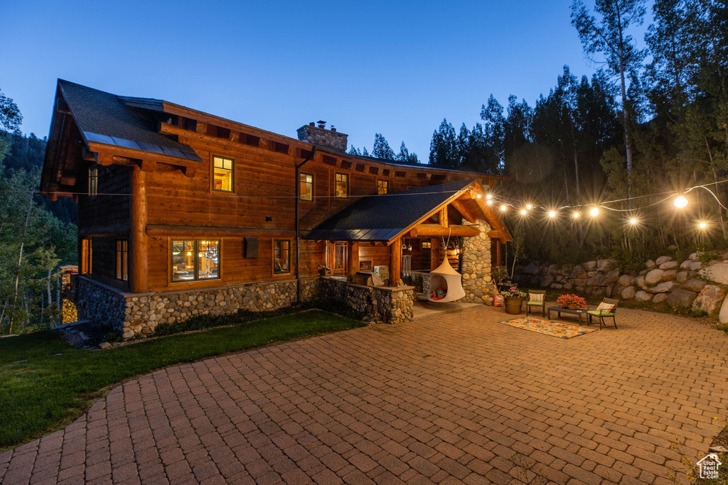 Back house at dusk with a patio area