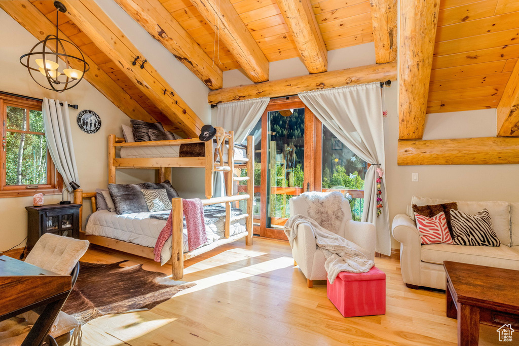Bedroom with multiple windows, light hardwood / wood-style floors, and a notable chandelier