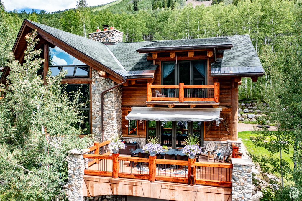 Back of house featuring a balcony and a deck