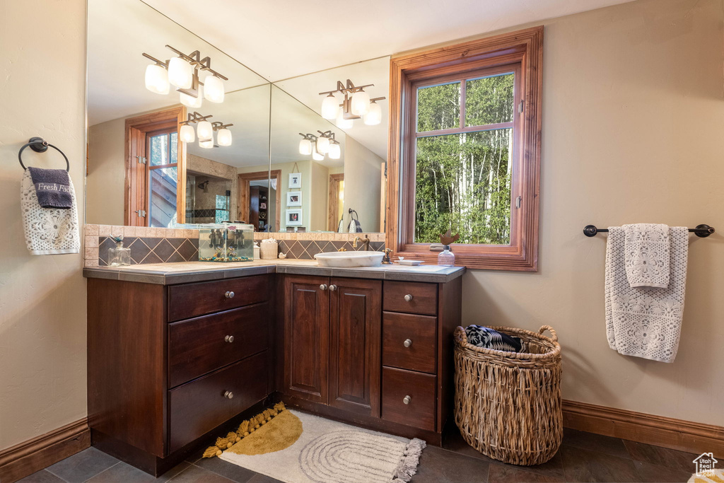 Bathroom with vanity and tasteful backsplash