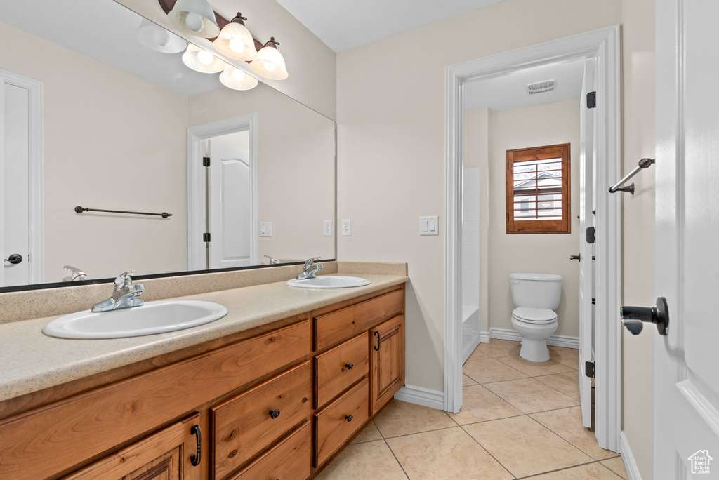 Bathroom with tile patterned floors, toilet, and vanity