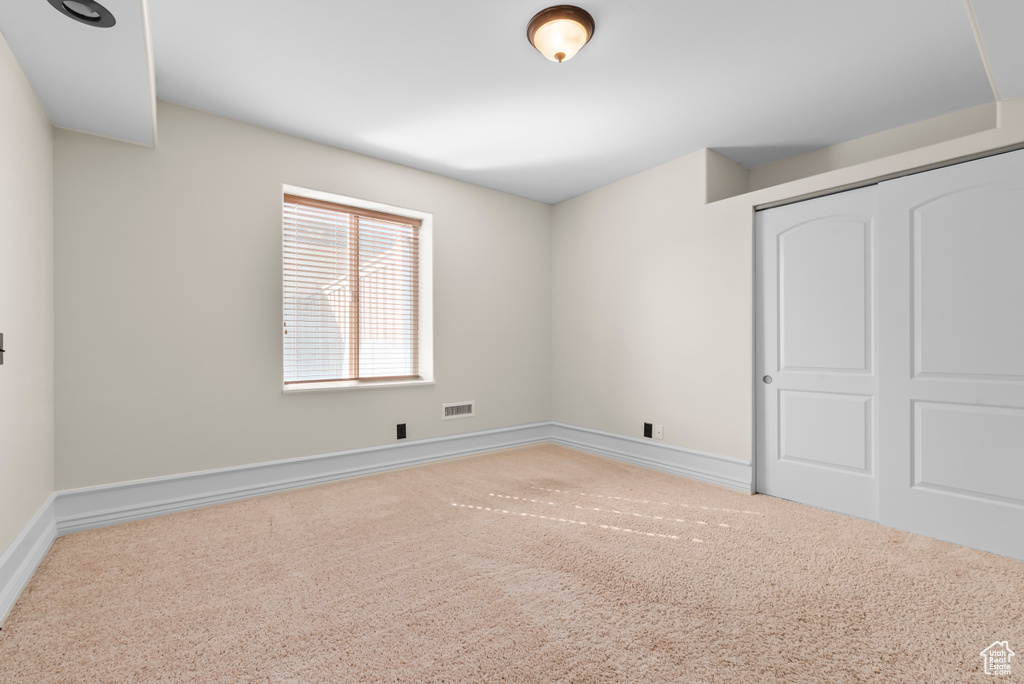 Unfurnished bedroom featuring a closet and carpet floors