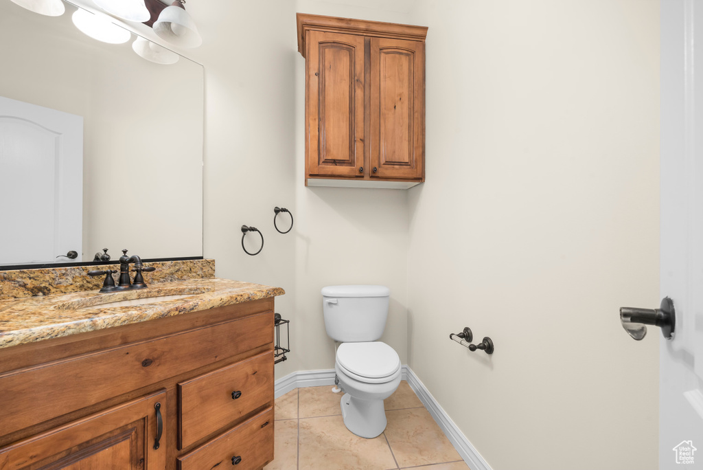 Bathroom with vanity, toilet, and tile patterned floors