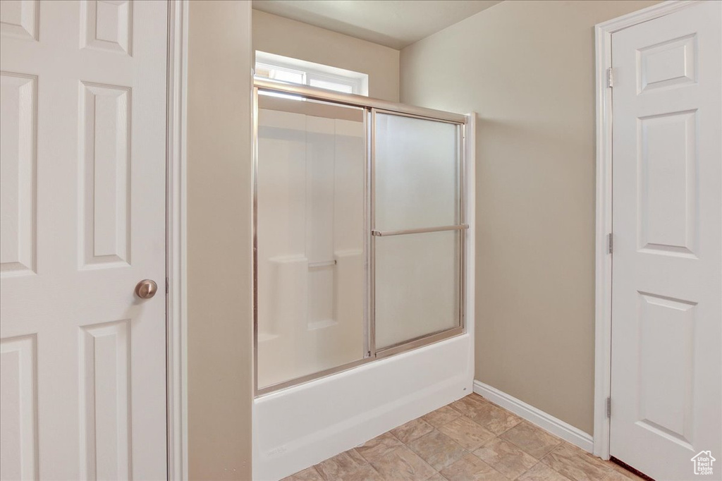 Bathroom with shower / bath combination with glass door