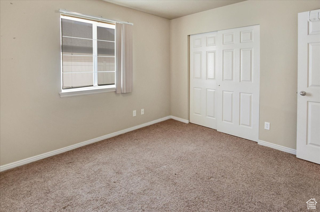 Unfurnished bedroom with a closet and carpet