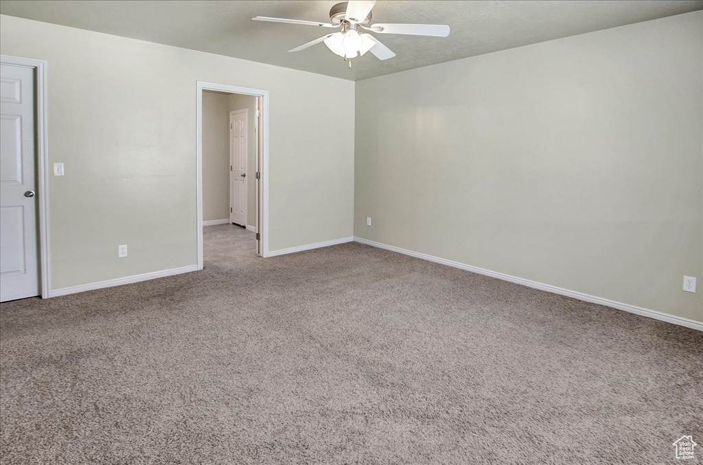 Carpeted empty room featuring ceiling fan
