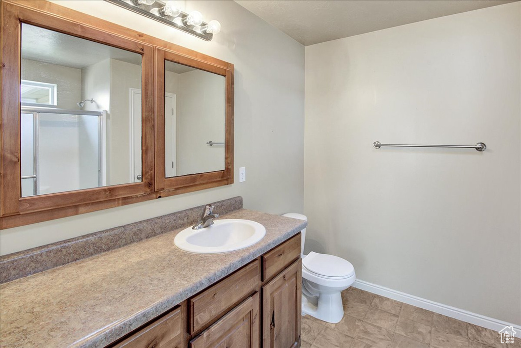 Bathroom with vanity, toilet, and a shower with door